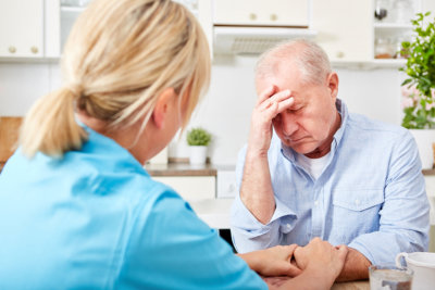 nurse comforts senior man with dementia
