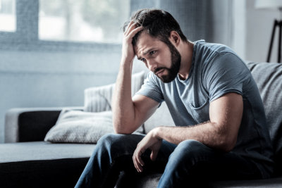 depressed man sitting on the sofa