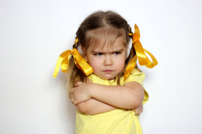 angry little girl with yellow bows and yellow shirt