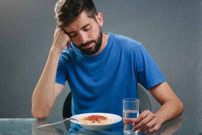 man with no appetite in front of the meal